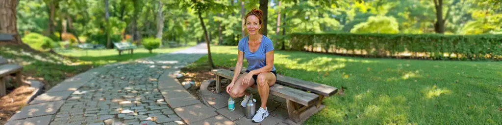 Claire Aldington, a fictional character, reflecting on her GLP-1 weight loss journey while seated on a park bench.