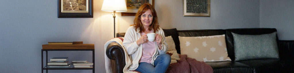 AI‑generated photo of Claire Aldington, fictional patient, resting with tea while coping with GLP‑1 side effects.